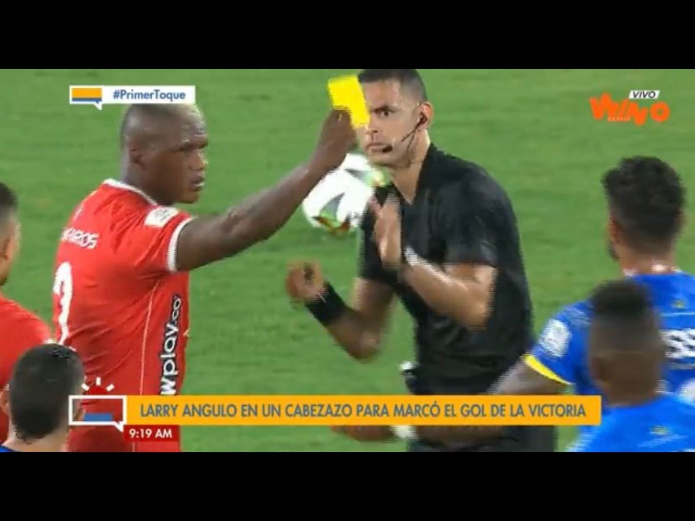 Marlon Torres takes yellow card from referee and shows it to a opponent player