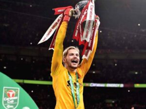 Liverpool goalkeeper Caoimhin Kelleher lifts the Carabao Cup trophy after heroics against Chelsea