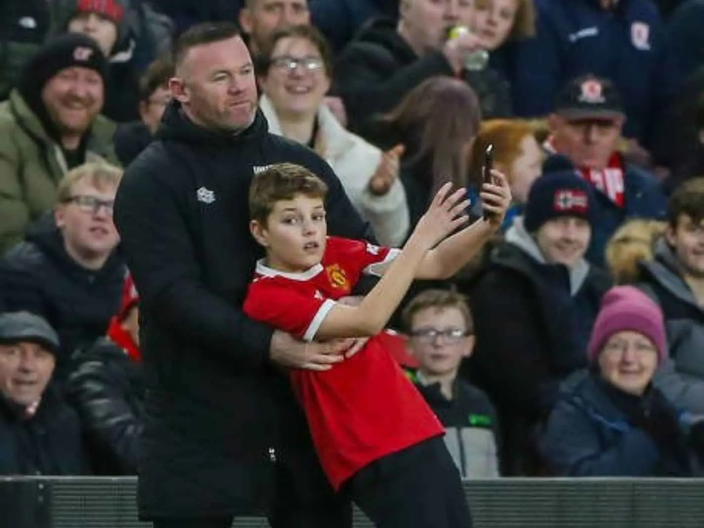 Young fan wearing Man United jersey grabs selfie with Wayne Rooney