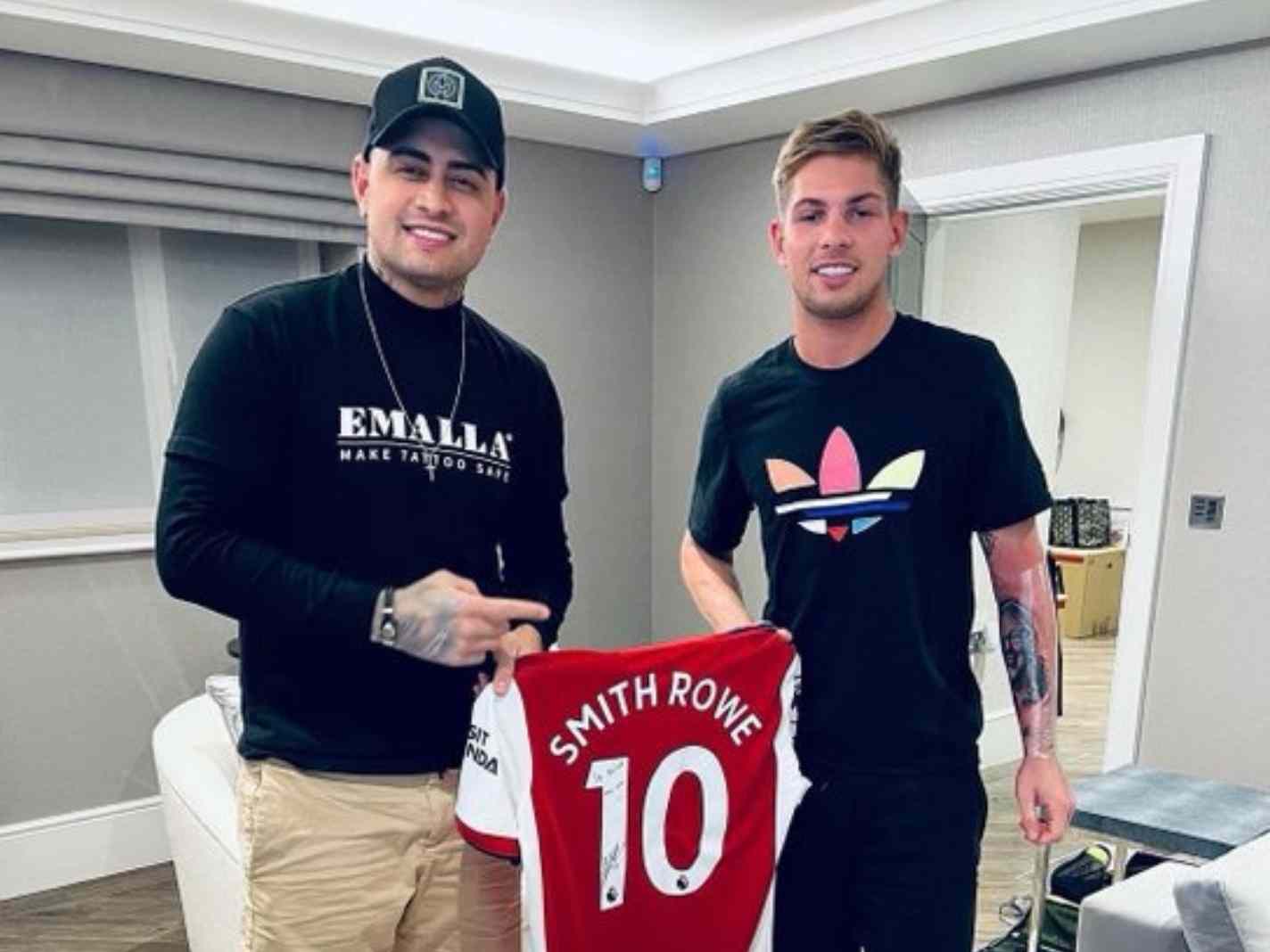 In this image - Emile Smith Rowe on the right, along with his tattoo artist on the left. Both of them holding an Arsenal home kit.