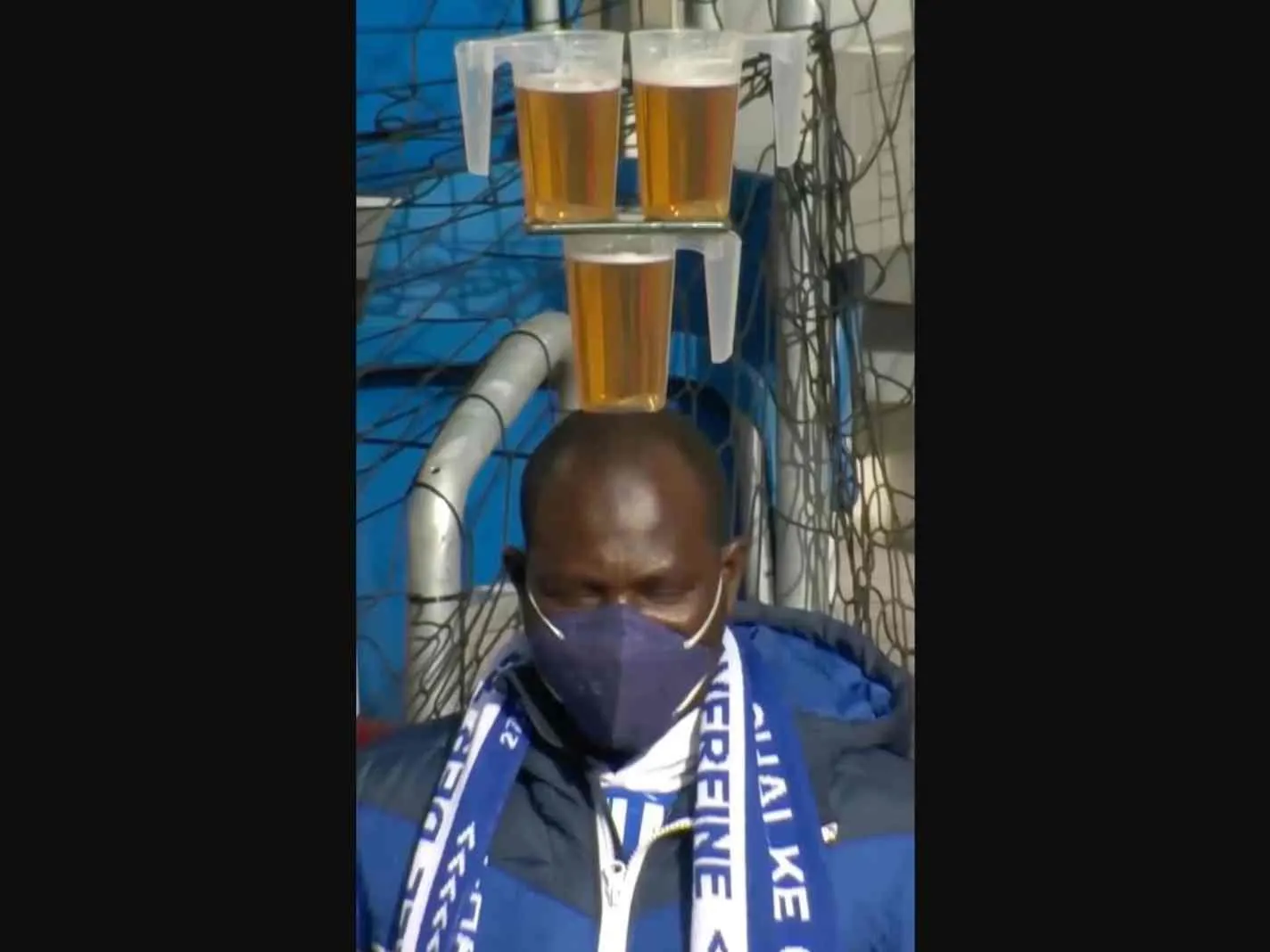 In this image - Schalke fan balancing 3 beer glasses on his head