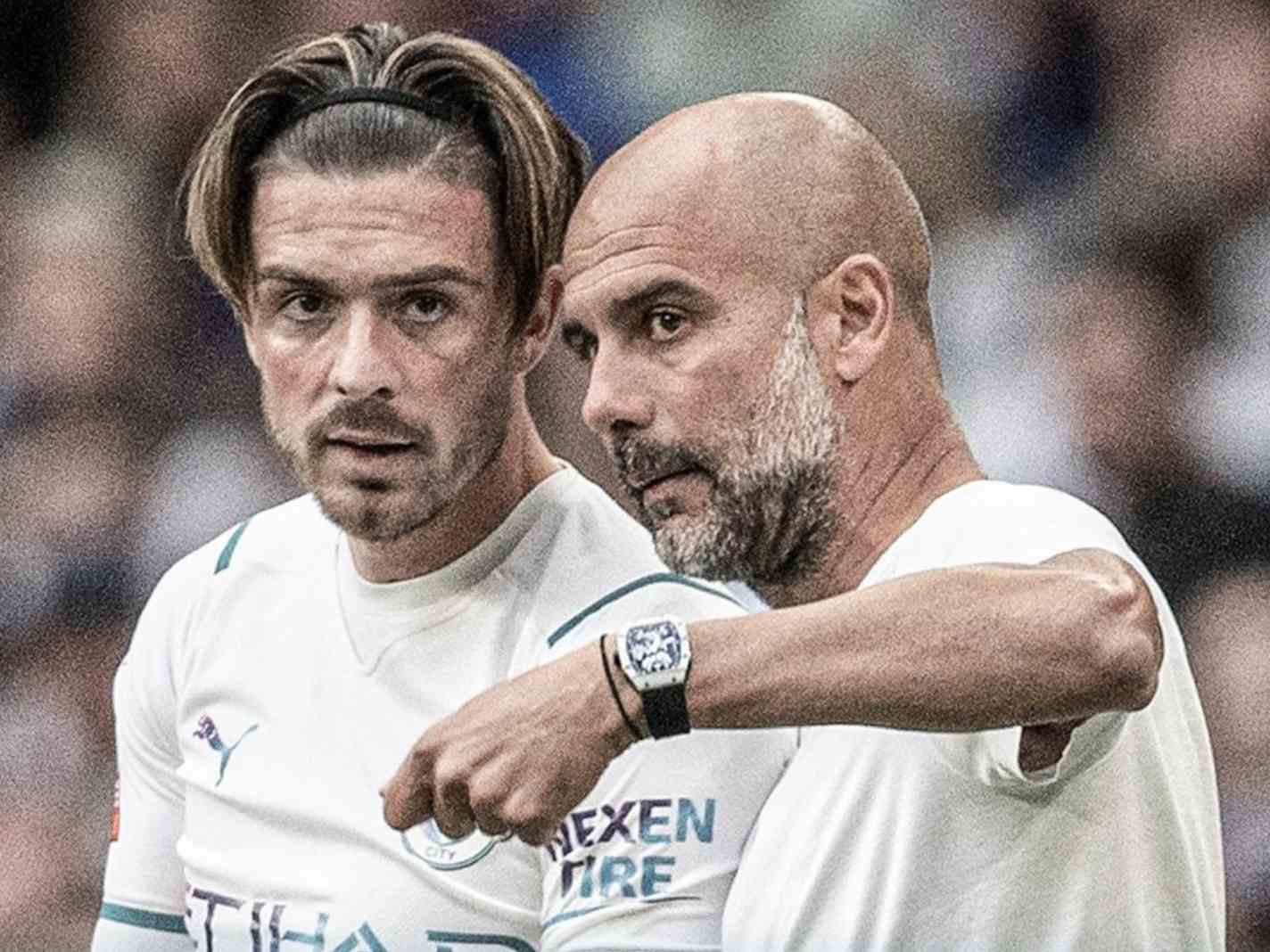 The photo shows Jack Grealish listening to instructions from Pep Guardiola