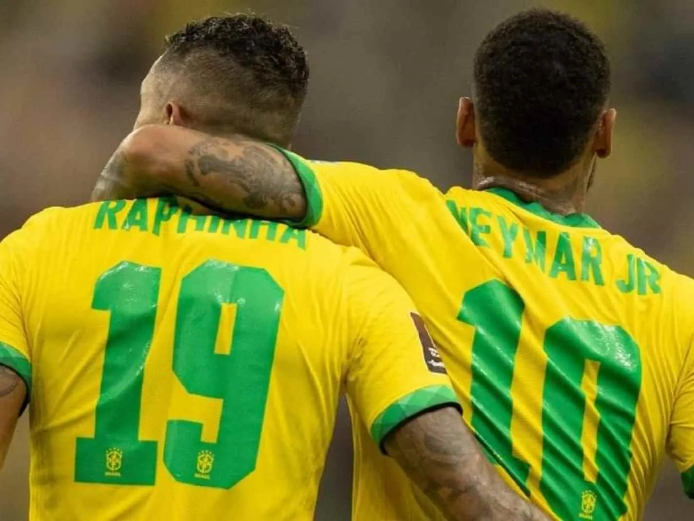The photo shows Neymar with his left hand wrapped around Raphinha's neck during a Brazil match.