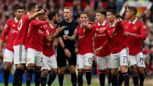 Man United players surround referee Craig Pawson