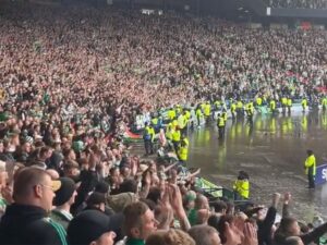 In this image – Celtic fans singing a chant at Ibrox